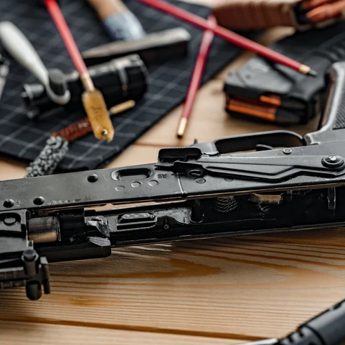 Inside Knightrunner Gunsmith Bench Disassembled rifle on a gunsmithing bench with cleaning tools